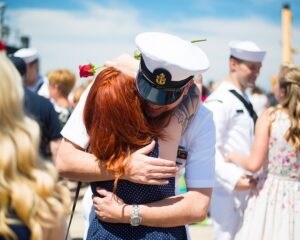 Sailor hugging woman