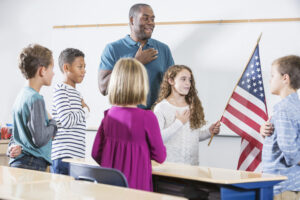 Teacher and school children reciting the Pledge of Allegiance