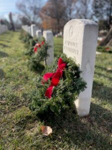 Headstone of an unknown soldier and a pine wreath with a red bow